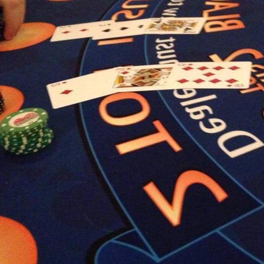 Card table displaying green poker chips and a two poker hands